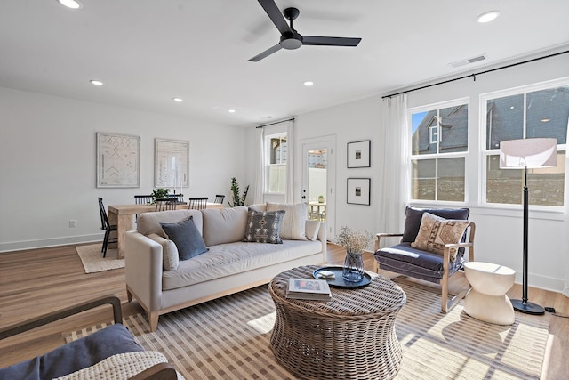 living room with recessed lighting, visible vents, ceiling fan, light wood-type flooring, and baseboards