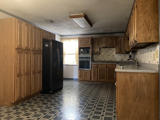 kitchen with visible vents, dark floors, light countertops, black appliances, and a sink