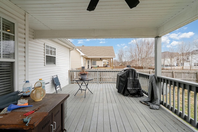 wooden deck with a ceiling fan, a grill, and fence