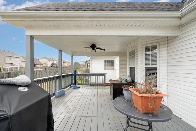 wooden deck featuring ceiling fan, area for grilling, fence, and a residential view