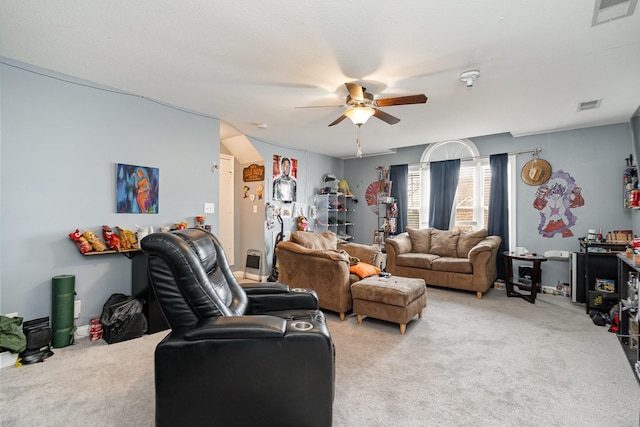 living area featuring ceiling fan, visible vents, and light colored carpet