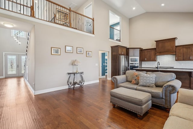 living room with baseboards, dark wood finished floors, french doors, high vaulted ceiling, and recessed lighting