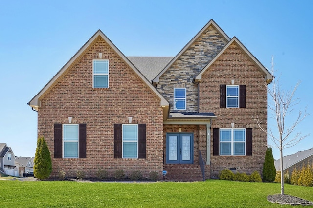 traditional-style house with french doors, brick siding, crawl space, stone siding, and a front lawn