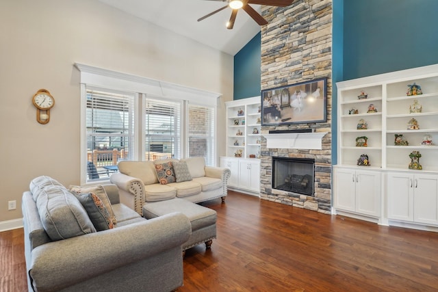 living room with dark wood-style floors, high vaulted ceiling, a ceiling fan, and a stone fireplace