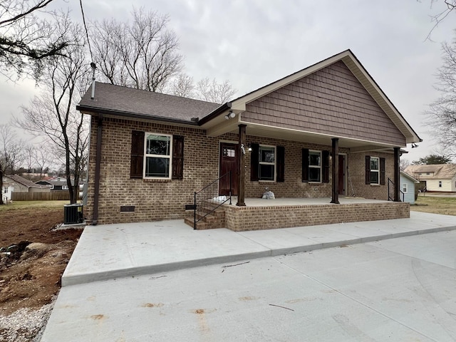 view of front of property with central AC, brick siding, and crawl space