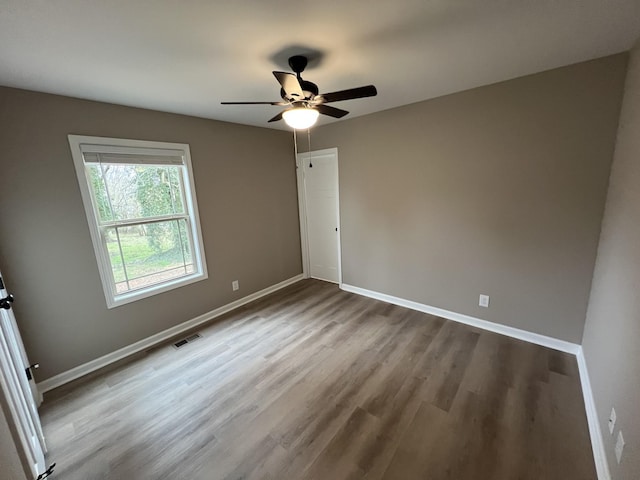 unfurnished bedroom with dark wood finished floors, a closet, visible vents, a ceiling fan, and baseboards