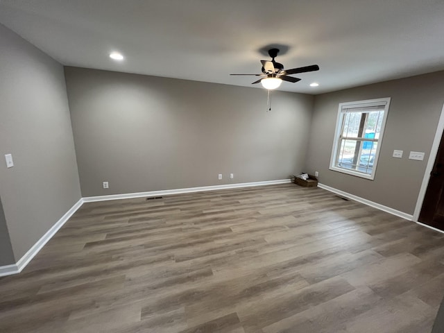 unfurnished room with recessed lighting, baseboards, and wood finished floors