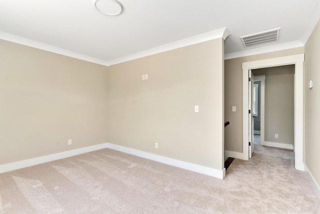 unfurnished room featuring light colored carpet, visible vents, crown molding, and baseboards