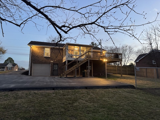 rear view of property with brick siding, fence, stairs, a yard, and a wooden deck