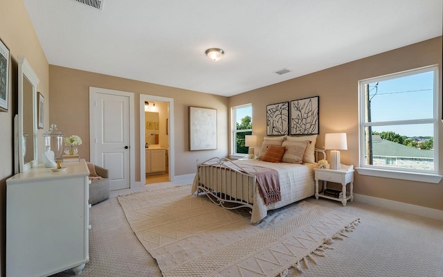 bedroom with multiple windows, light colored carpet, visible vents, and baseboards