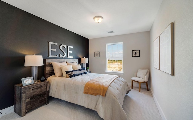 bedroom with light colored carpet, visible vents, and baseboards