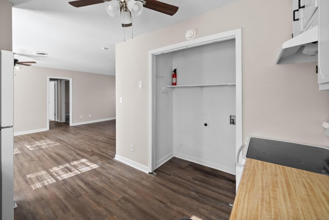 interior space featuring ceiling fan, under cabinet range hood, electric range, wood finished floors, and baseboards