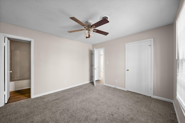 unfurnished bedroom featuring a ceiling fan, carpet, baseboards, and ensuite bathroom