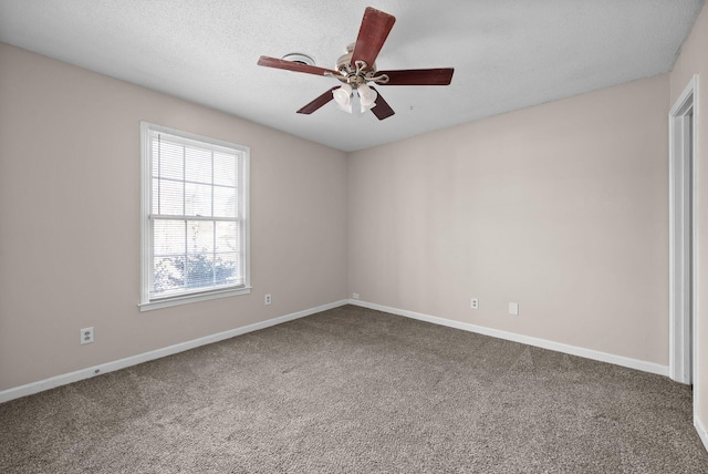 empty room with carpet flooring, ceiling fan, a textured ceiling, and baseboards