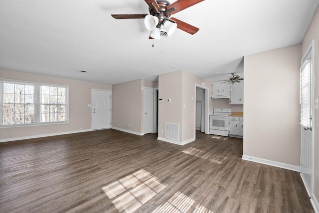 unfurnished living room with dark wood-style floors, baseboards, visible vents, and a wealth of natural light