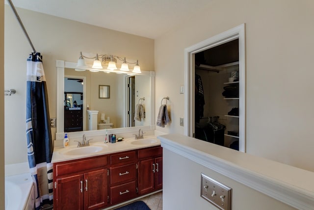 full bath with double vanity, toilet, a sink, and tile patterned floors