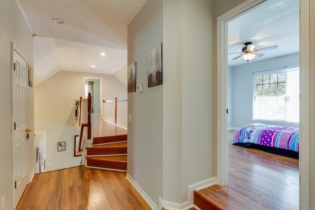 hallway with baseboards, vaulted ceiling, wood finished floors, and recessed lighting