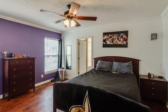 bedroom with visible vents, a ceiling fan, dark wood-style floors, a textured ceiling, and crown molding