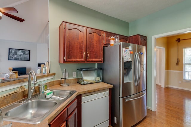 kitchen featuring a sink, a ceiling fan, light wood-type flooring, stainless steel fridge with ice dispenser, and dishwasher