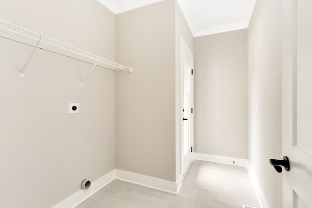 laundry area with laundry area, crown molding, electric dryer hookup, and baseboards