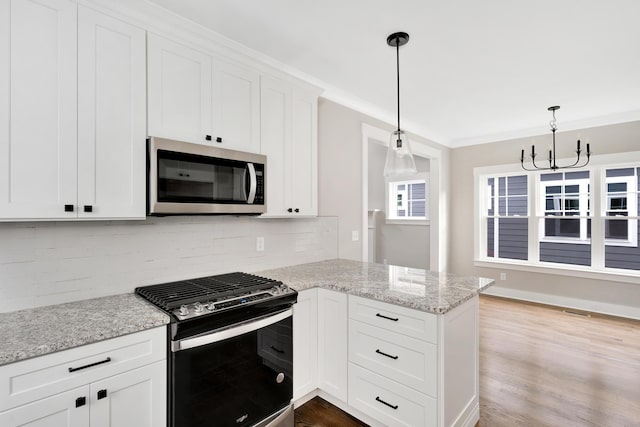 kitchen featuring tasteful backsplash, stainless steel microwave, ornamental molding, a peninsula, and gas stove