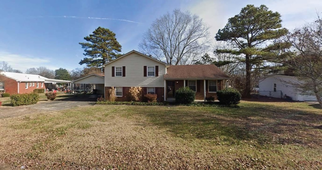 tri-level home featuring a front yard and brick siding