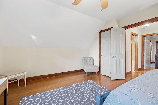 bedroom featuring a ceiling fan, lofted ceiling, baseboards, and wood finished floors