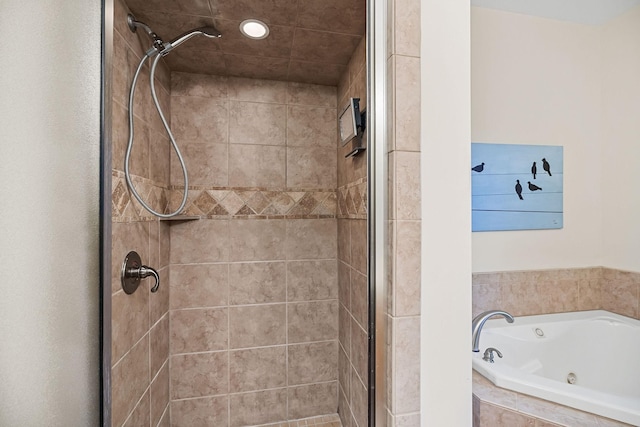 bathroom with recessed lighting, a shower stall, and a tub with jets