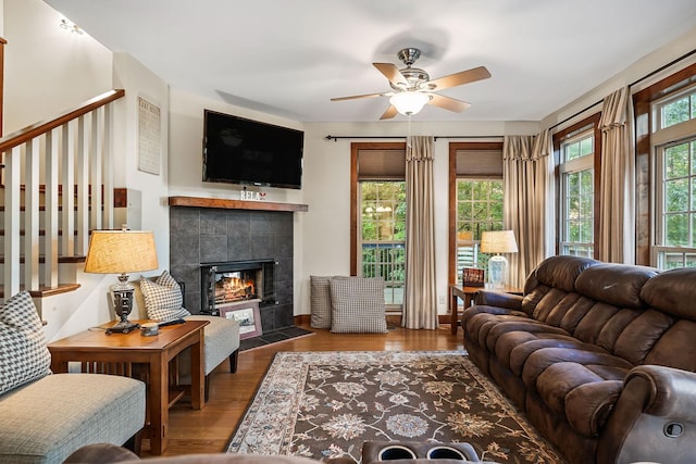 living area with ceiling fan, a fireplace, plenty of natural light, and wood finished floors