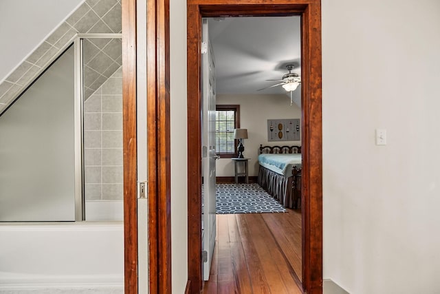 corridor featuring baseboards and hardwood / wood-style flooring