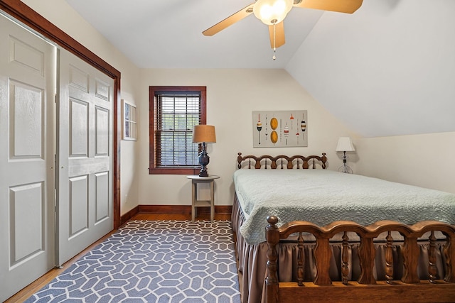 bedroom with ceiling fan, baseboards, vaulted ceiling, and wood finished floors