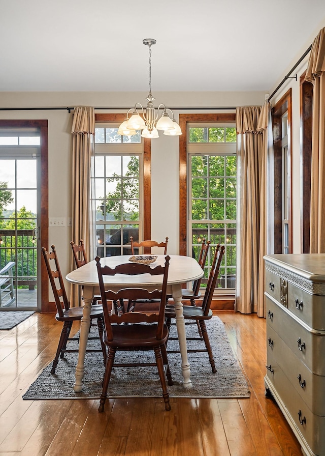 dining space with light wood-style floors and a notable chandelier