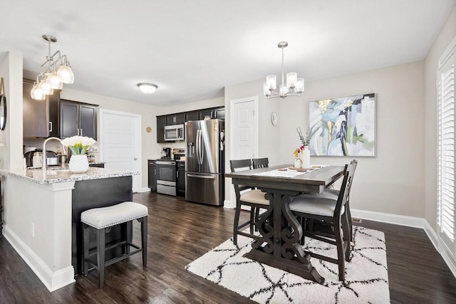 dining area featuring dark wood-style floors, a chandelier, and baseboards