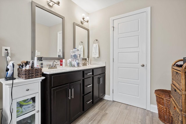 bathroom with double vanity, baseboards, and a sink