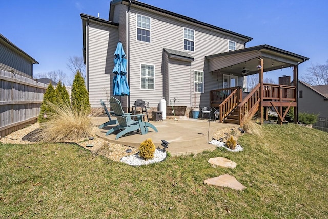 back of house with ceiling fan, stairs, a deck, a yard, and a patio area