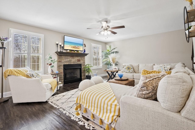 living area with a fireplace, dark wood-style floors, baseboards, and ceiling fan