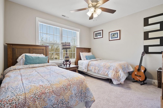 carpeted bedroom with visible vents, baseboards, and ceiling fan