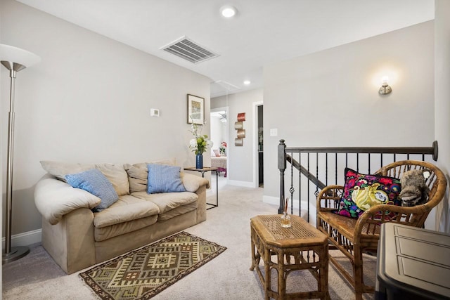 living room with visible vents, baseboards, attic access, recessed lighting, and light colored carpet