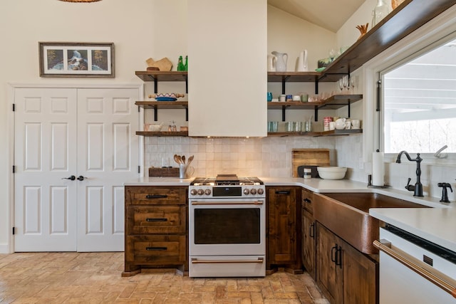 kitchen featuring gas range oven, white dishwasher, open shelves, and light countertops