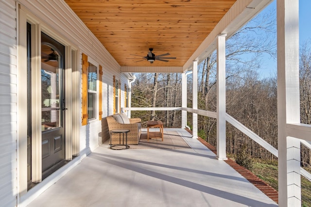 unfurnished sunroom featuring wood ceiling and a ceiling fan