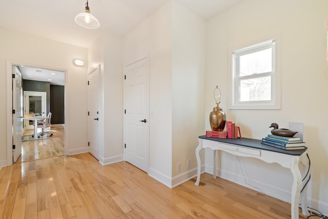 corridor with baseboards and wood finished floors