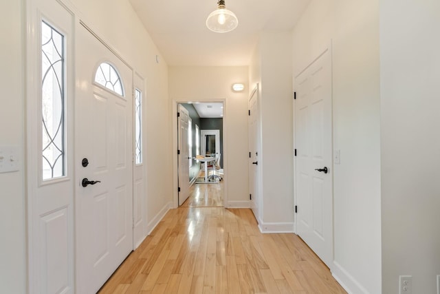 entrance foyer with light wood-style floors and baseboards