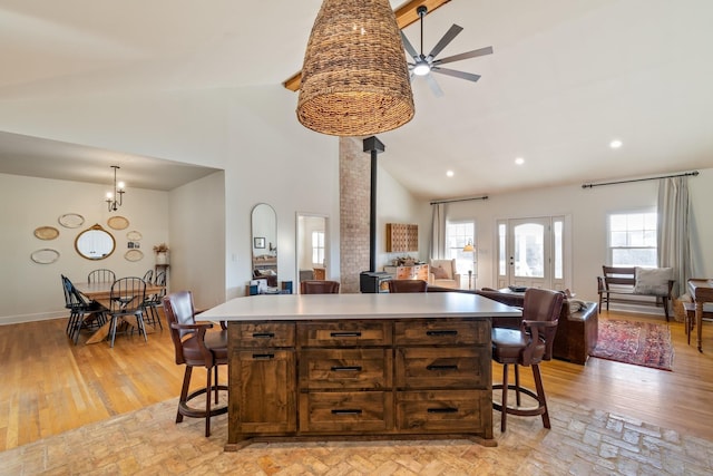 kitchen featuring a wood stove, plenty of natural light, and a kitchen breakfast bar