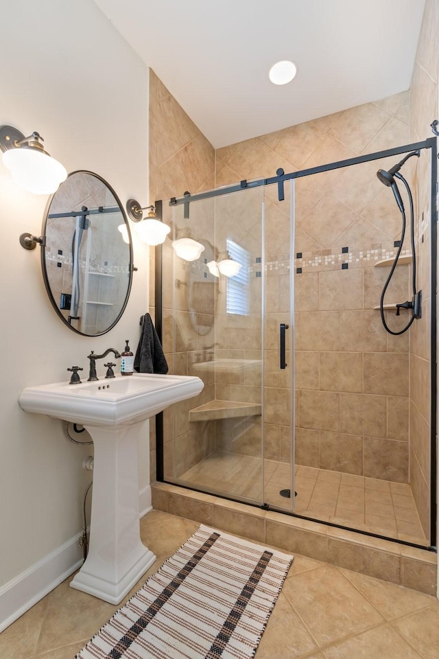 full bath featuring a shower stall, baseboards, and tile patterned floors