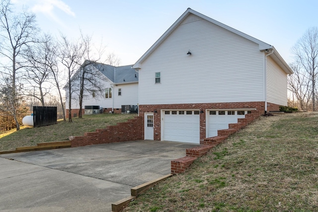 view of side of home featuring a garage, central AC, and concrete driveway