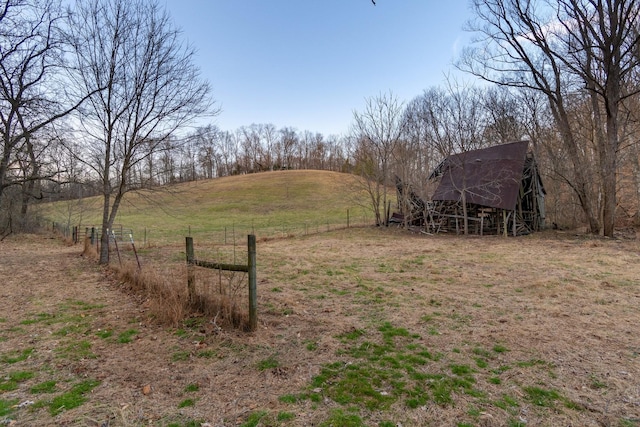 view of yard featuring an outdoor structure, a barn, and fence