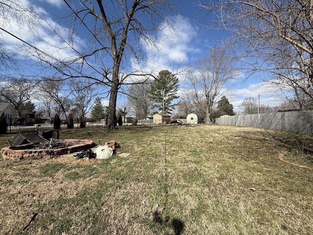 view of yard with a shed, an outdoor structure, and fence