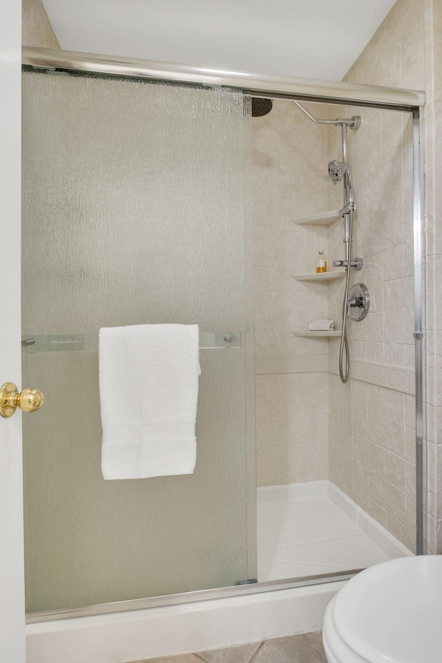 bathroom featuring a stall shower and toilet