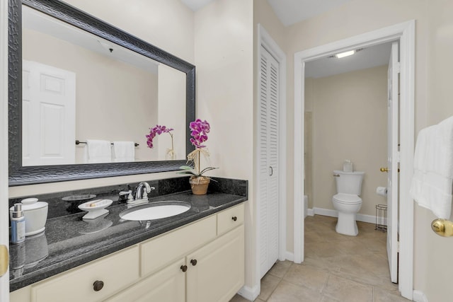 bathroom with toilet, vanity, baseboards, a closet, and tile patterned floors