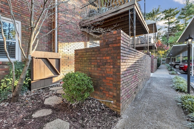 view of side of property featuring brick siding and fence